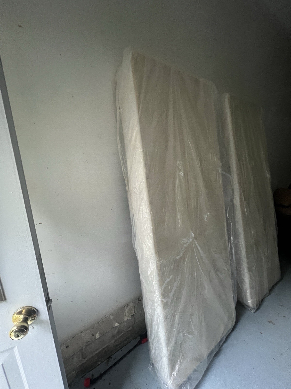 2 White Rectangle Mattresses Wrapped in Plastic Wrap, No Brand or Size Shown