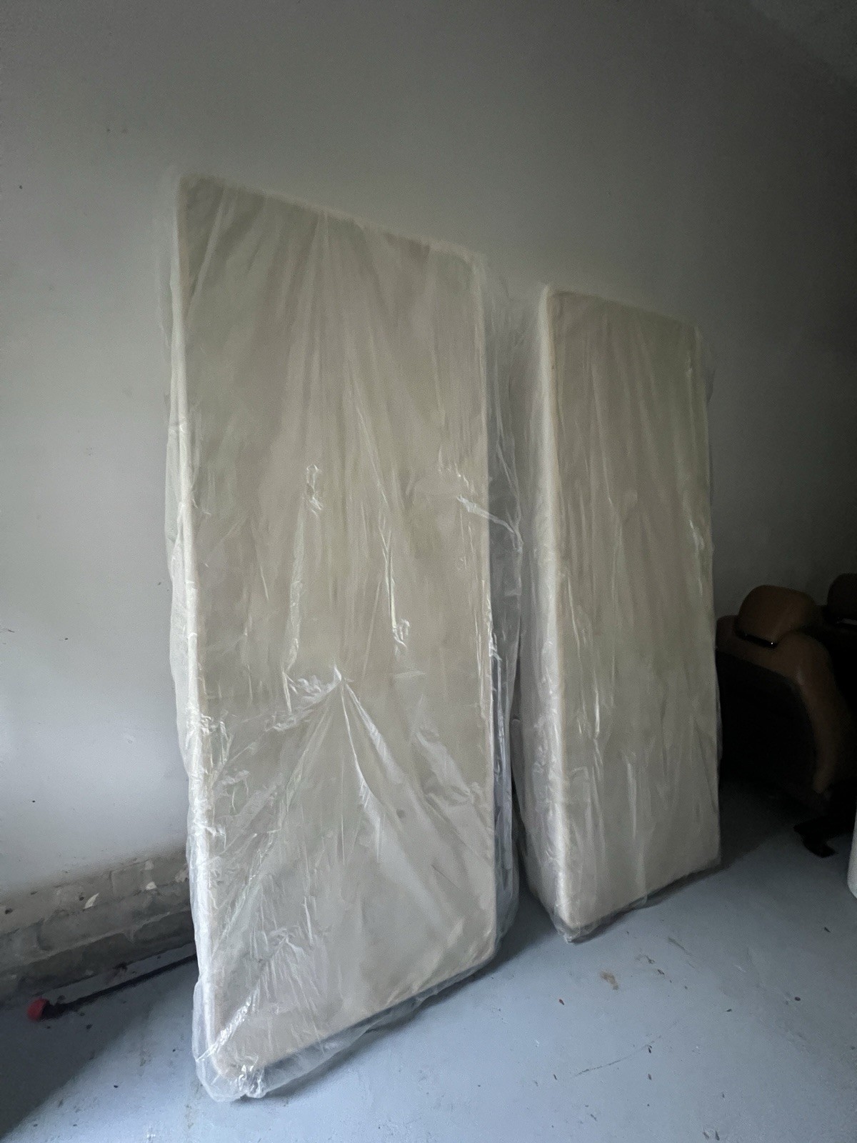 2 White Rectangle Mattresses Wrapped in Plastic Wrap, No Brand or Size Shown